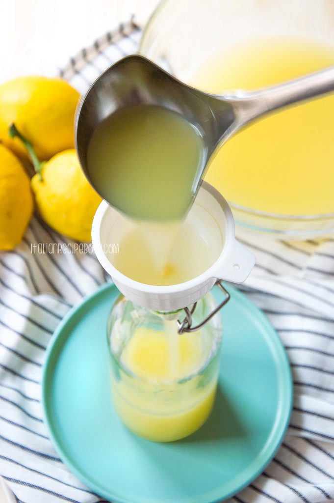 bottle limoncello using a funnel