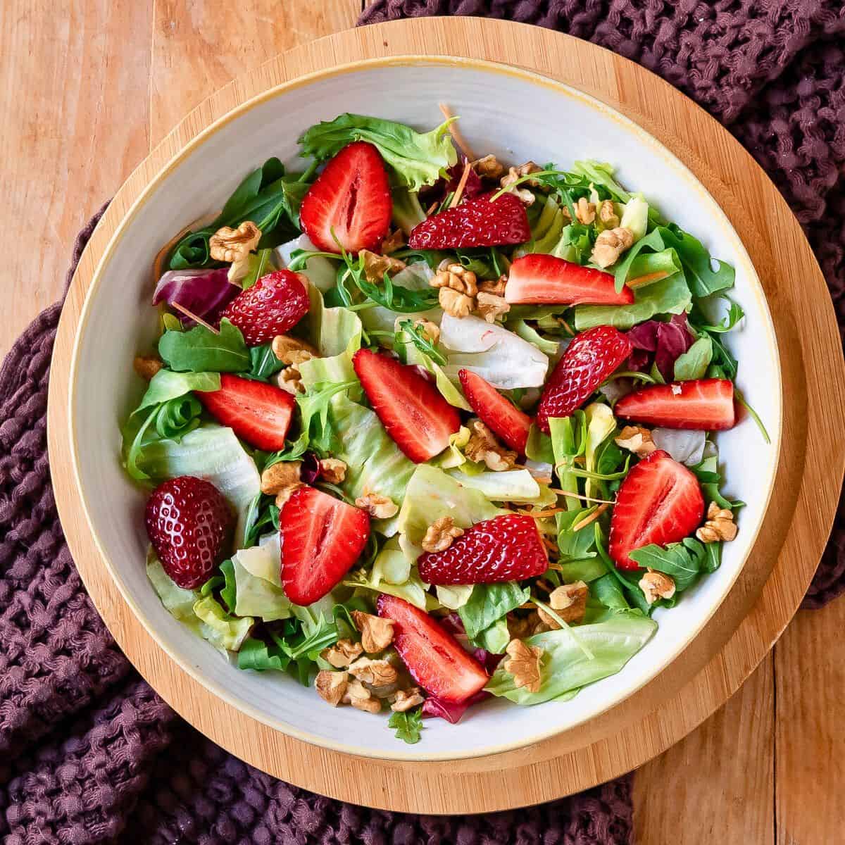 Arranging salad ingredients in a bowl.