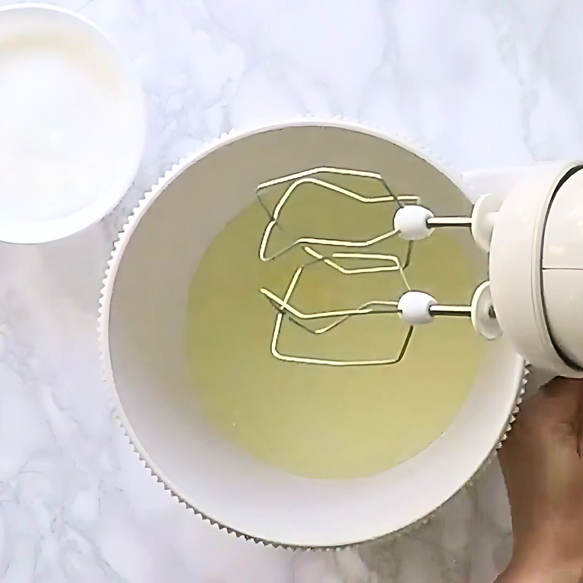 Egg whites in a bowl of a stand mixer.