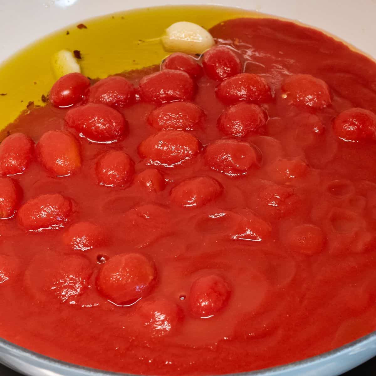 Adding tomatoes to soffritto.