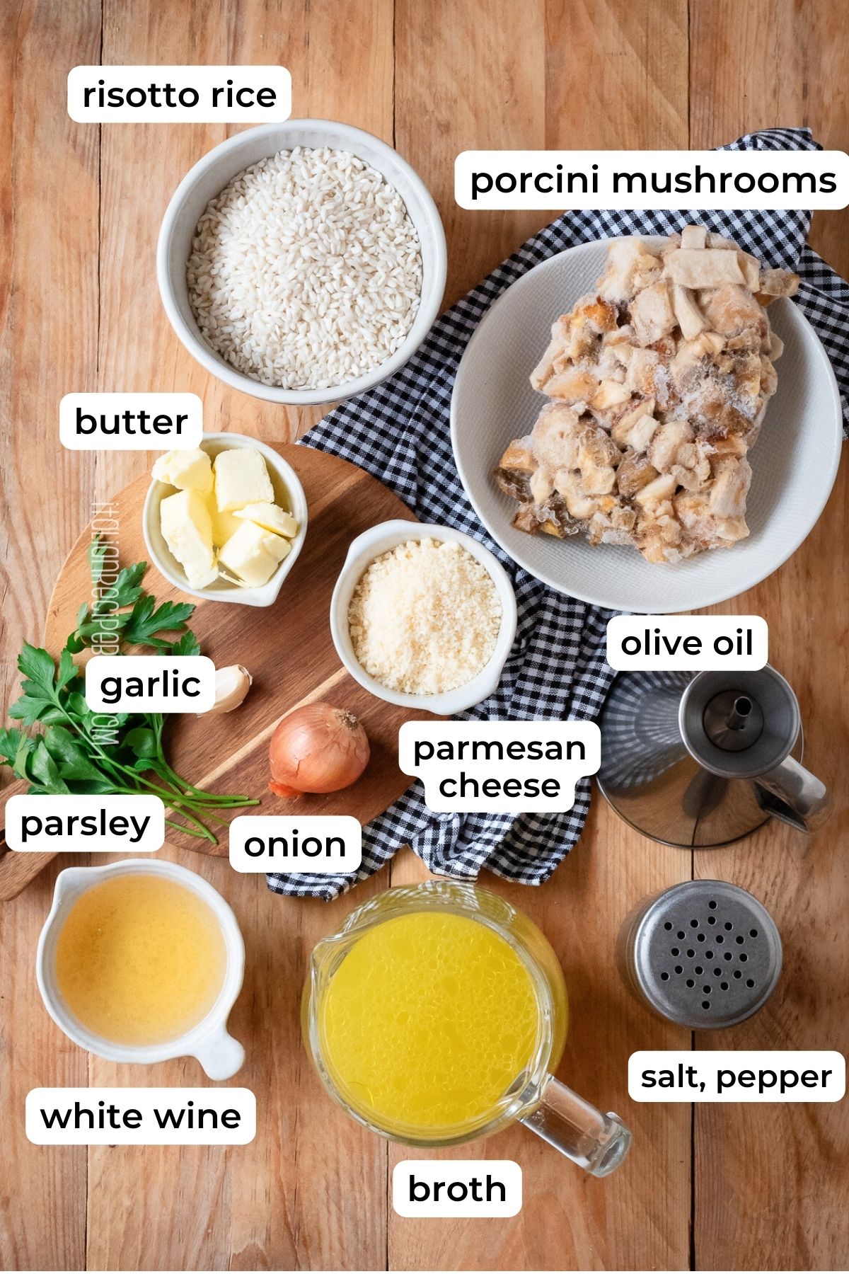 Ingredients needed to make porcini mushroom risotto laid on a wooden surface.