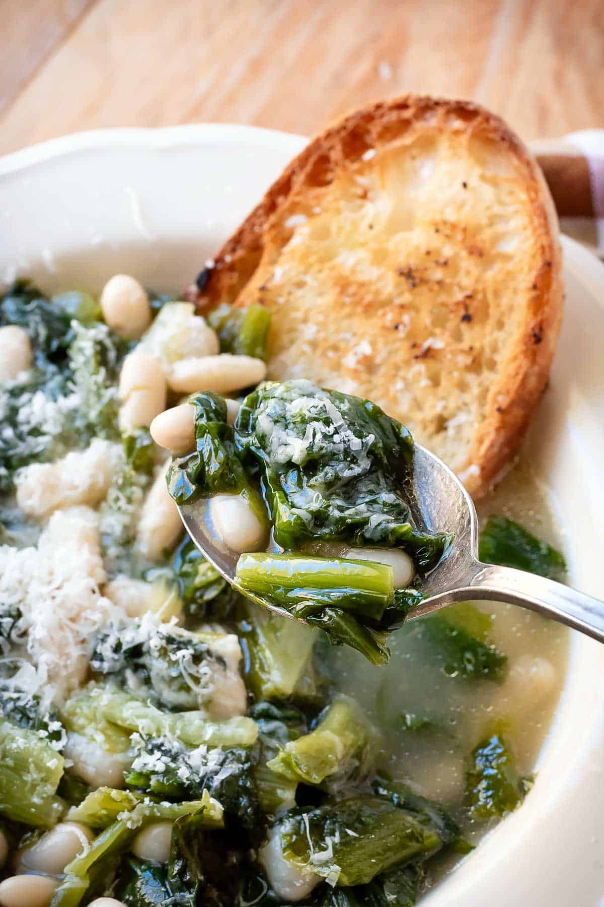 Scooping the soup with a spoon.
