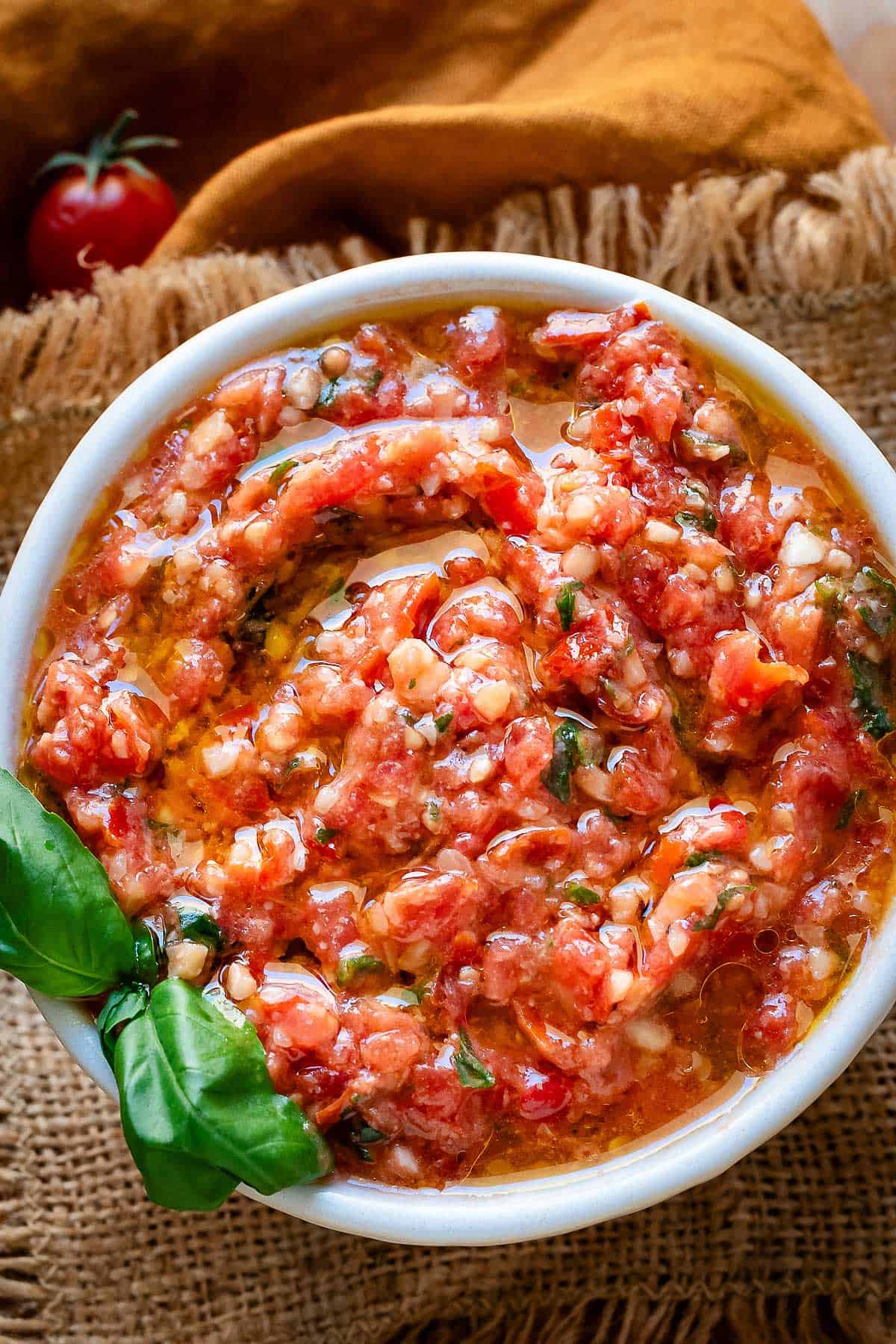Pesto alla tranapese in a while bowl garnished with fresh basil.