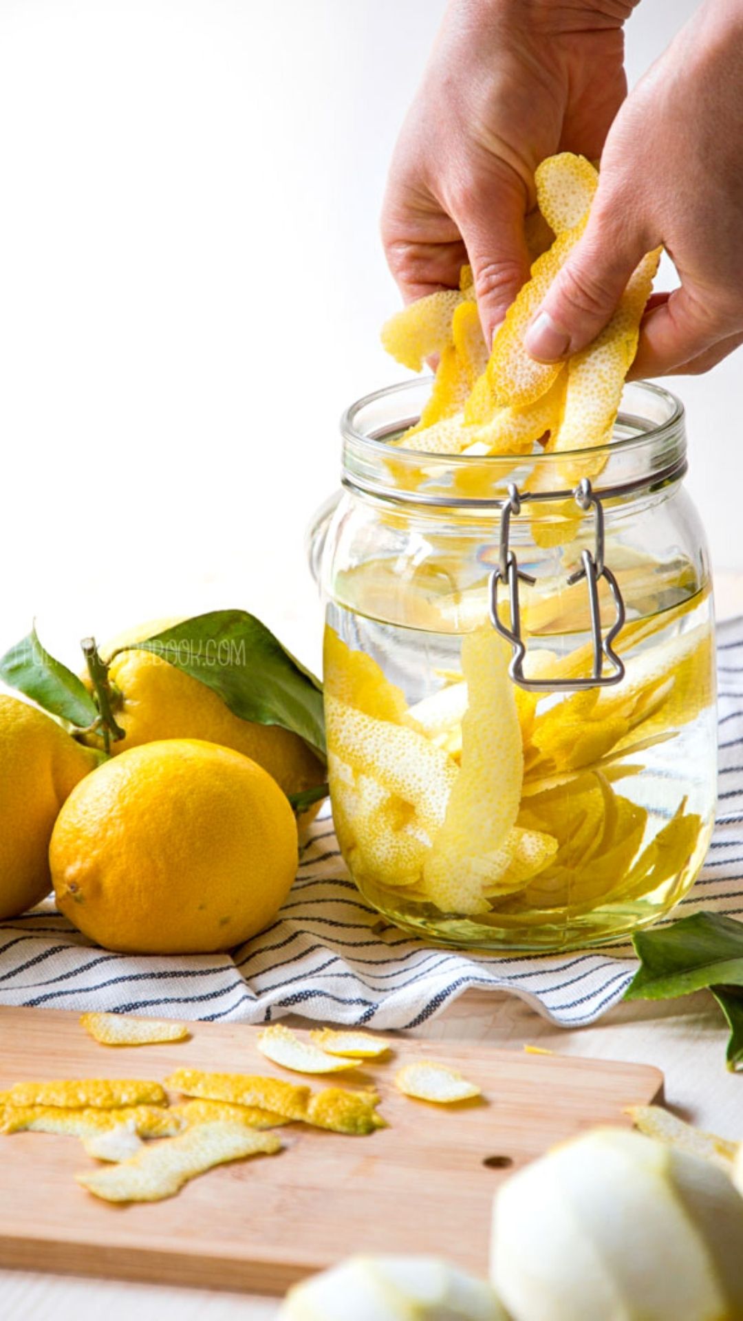 adding lemon peels to a jar with alcohol