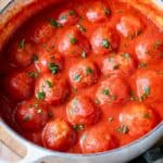 Italian meatballs in tomato sauce in a white pot.