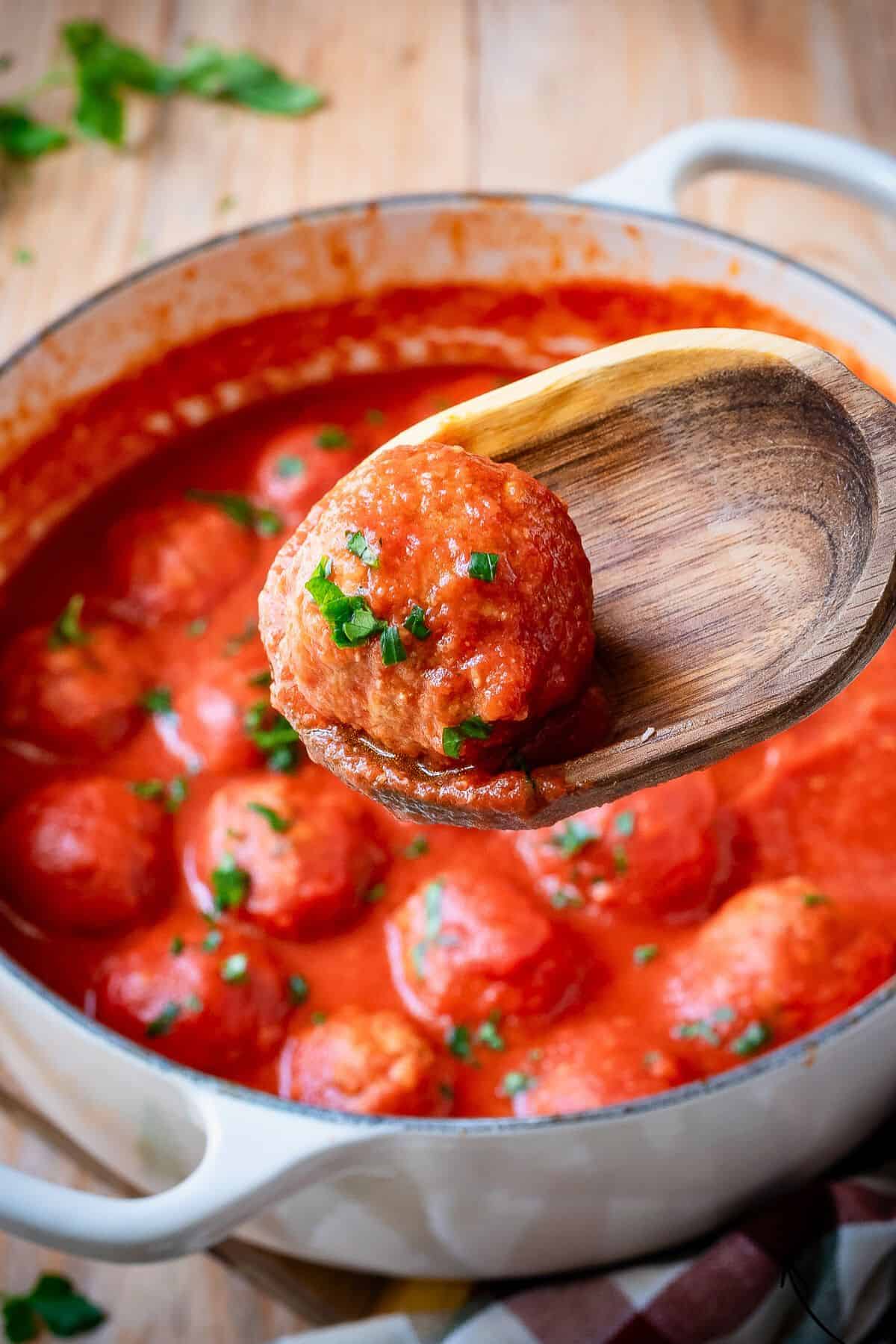 Polpette in tomato sauce garnished with parsley.