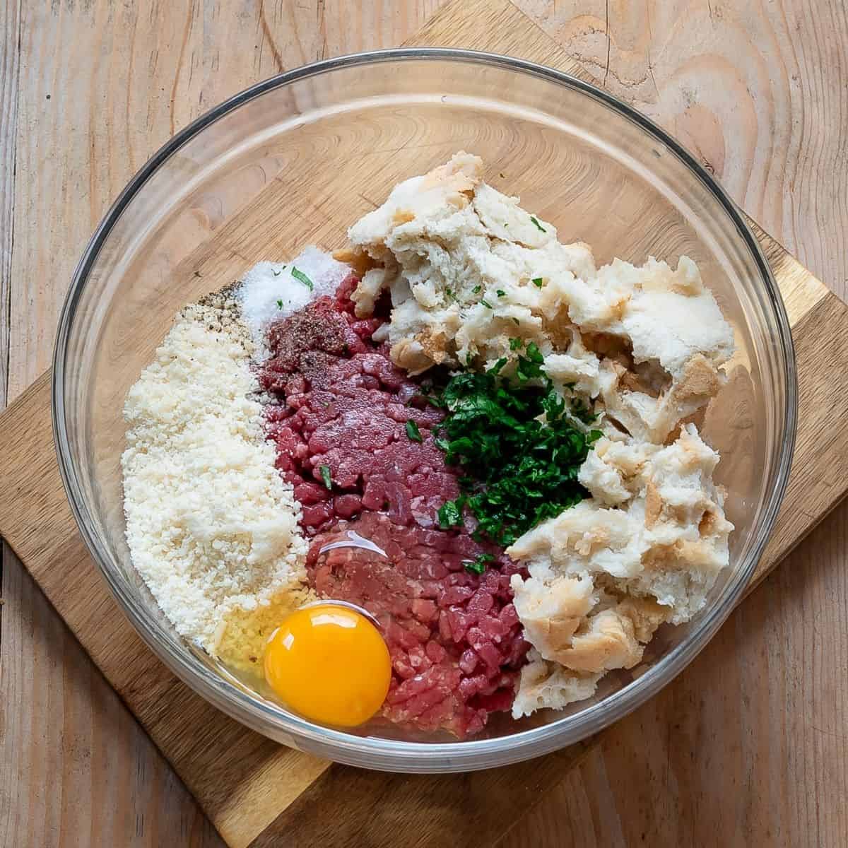 All ingredients for polpette added in a bowl.