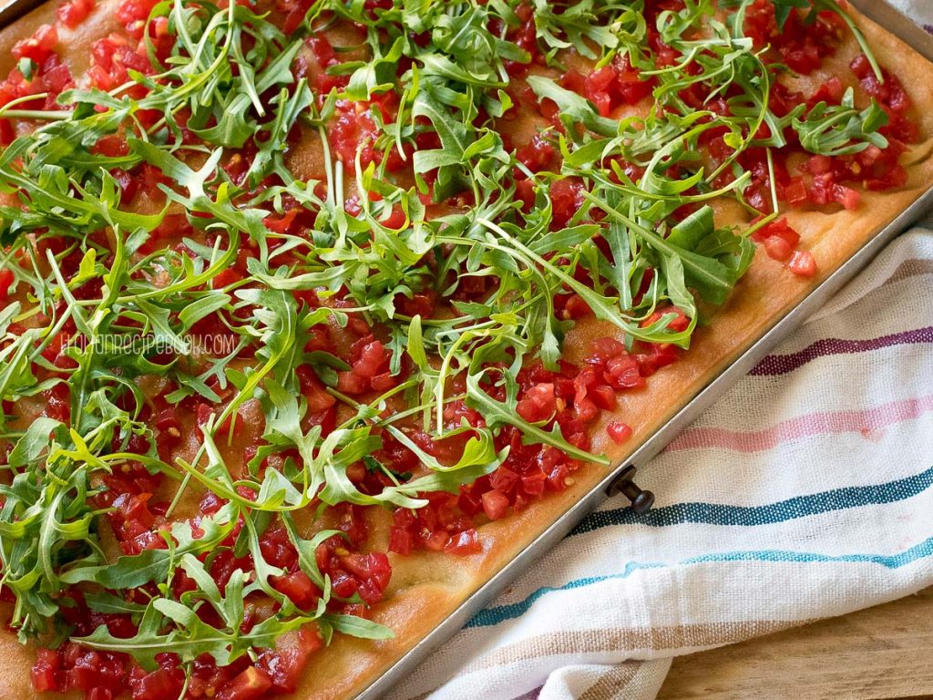 focaccia topping with arugula and tomatoes 