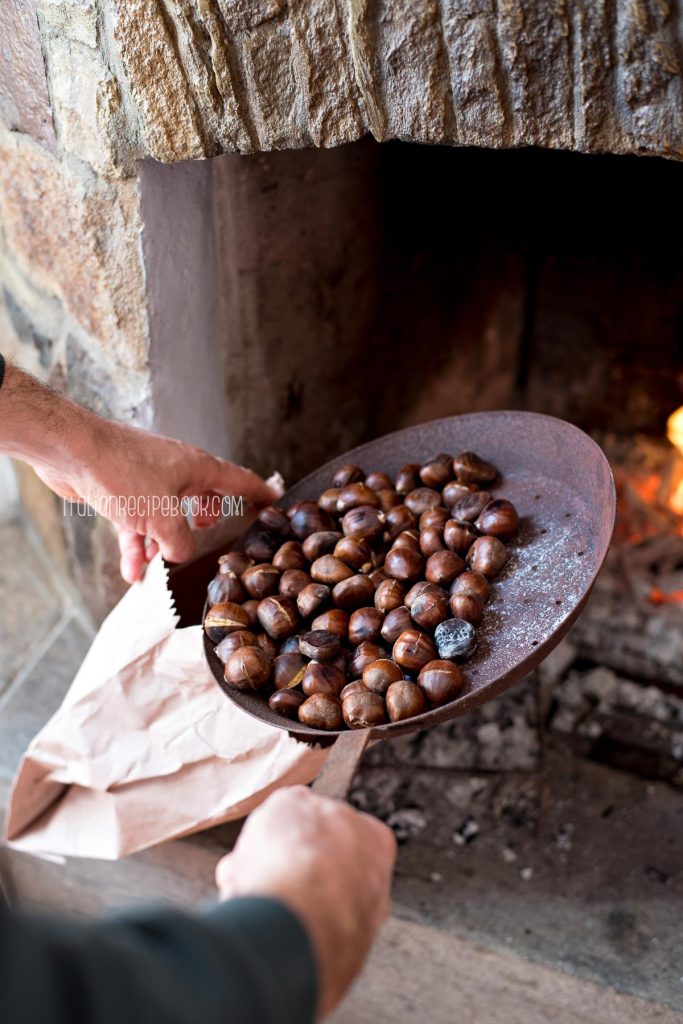 putting chestuts in a brown bag after roasting