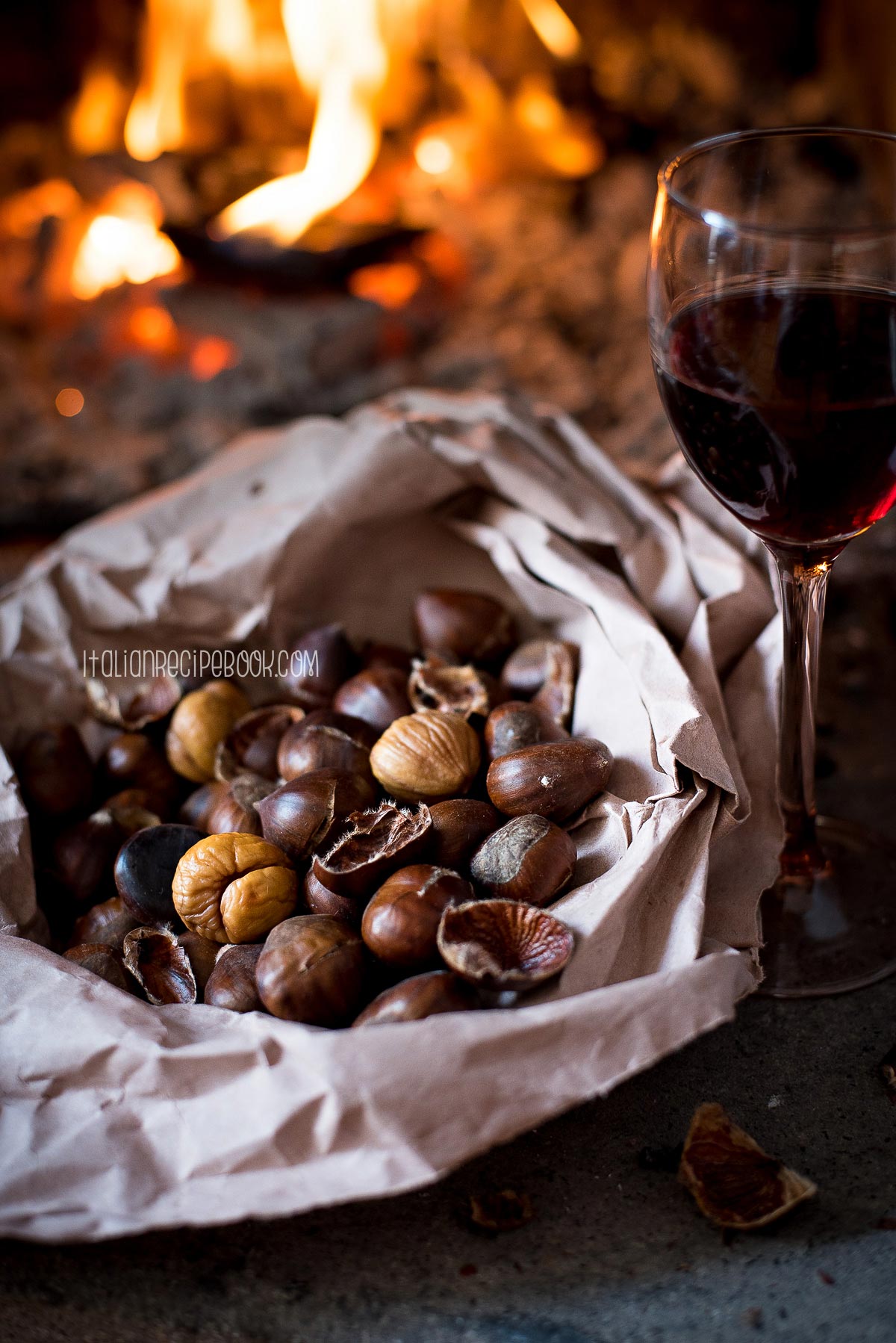 Roasted chestnuts with a glass of red wine on the side.