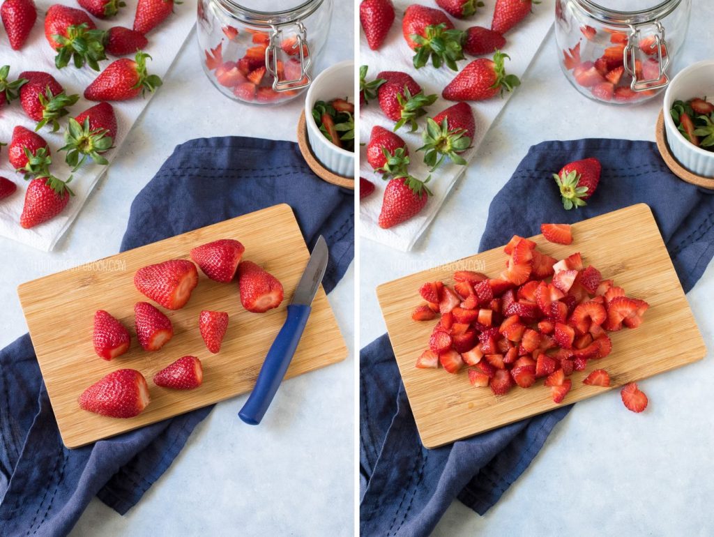 Strawberries cut in small pieces on a wooden board.