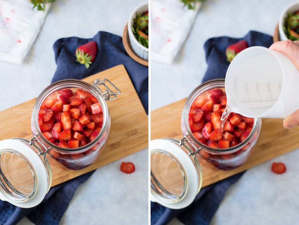 Placing strawberries in a glass jar with alcohol.