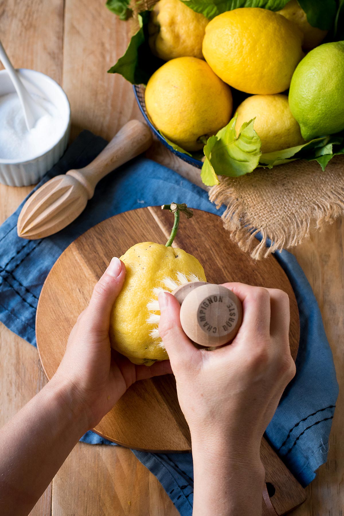 Scrubbing lemons with a brush.