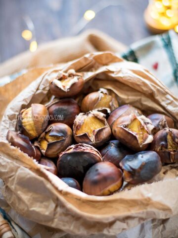roasted chestnuts in a paper bag with lights in the background