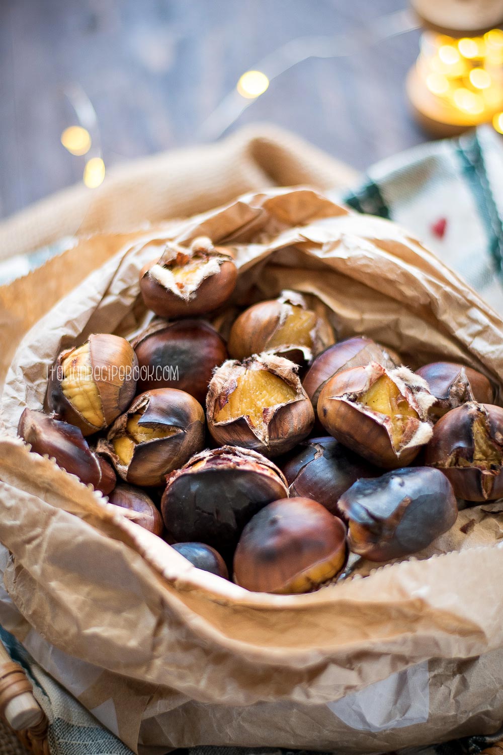 roasted chestnuts in a paper bag with lights in the background