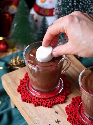Dipping a marshmallow into a cup of Italian hot chocolate.