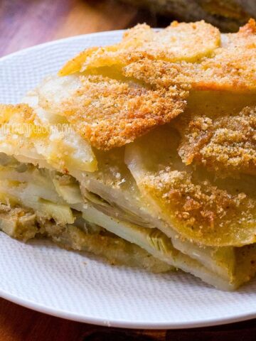 Potato artichoke gratin slice on a plate.