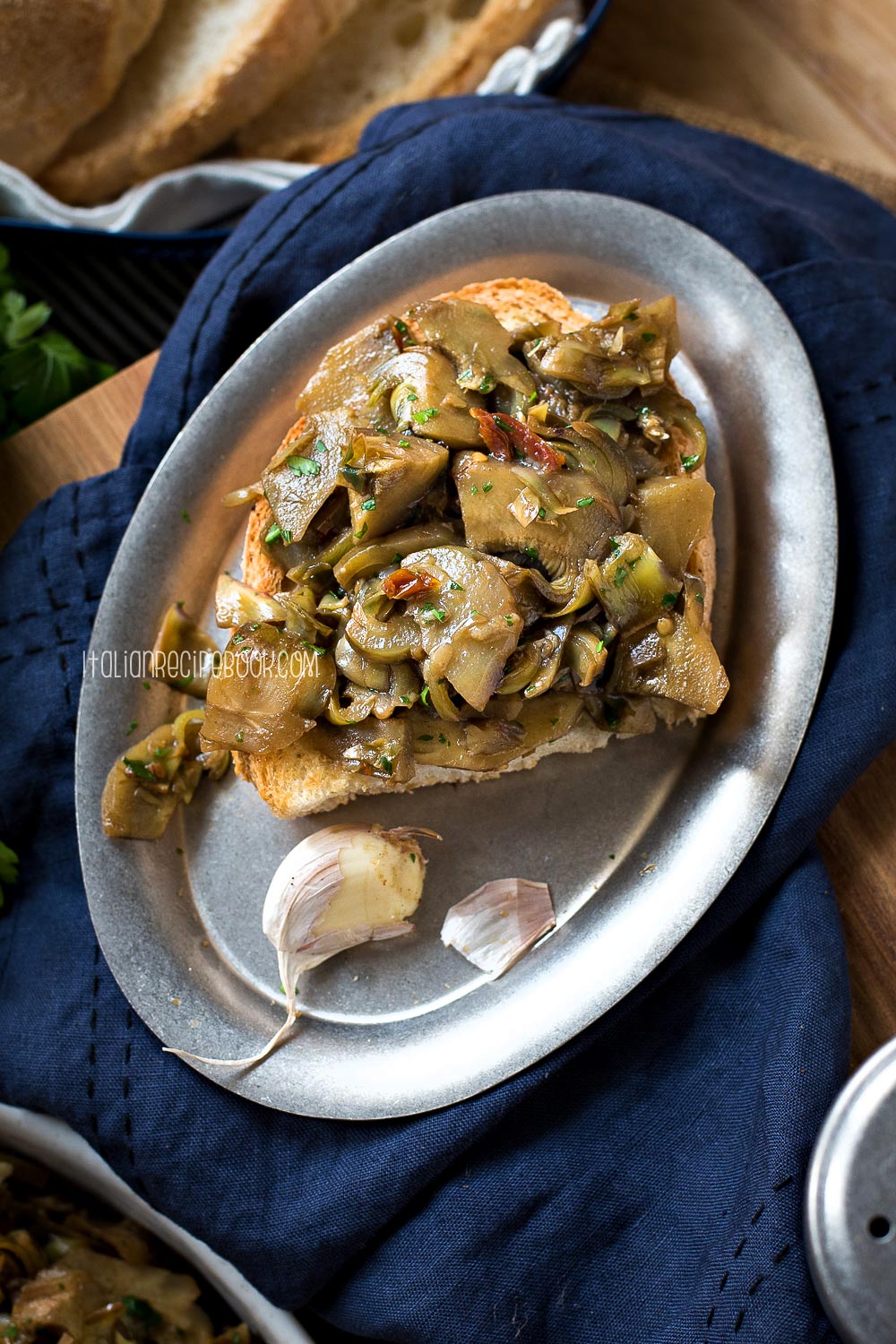 braised artichoke bruschetta on a metal plate