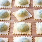 spinach and ricotta ravioli on a wooden board