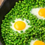 eggs and peas in a cast iron pan