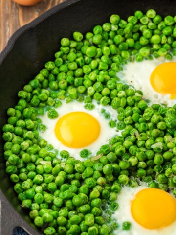 eggs and peas in a cast iron pan