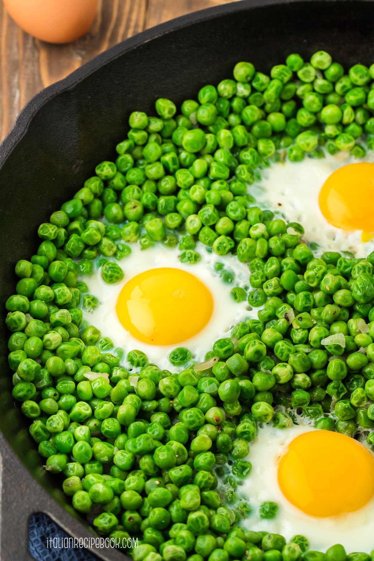 eggs and peas in a cast iron pan