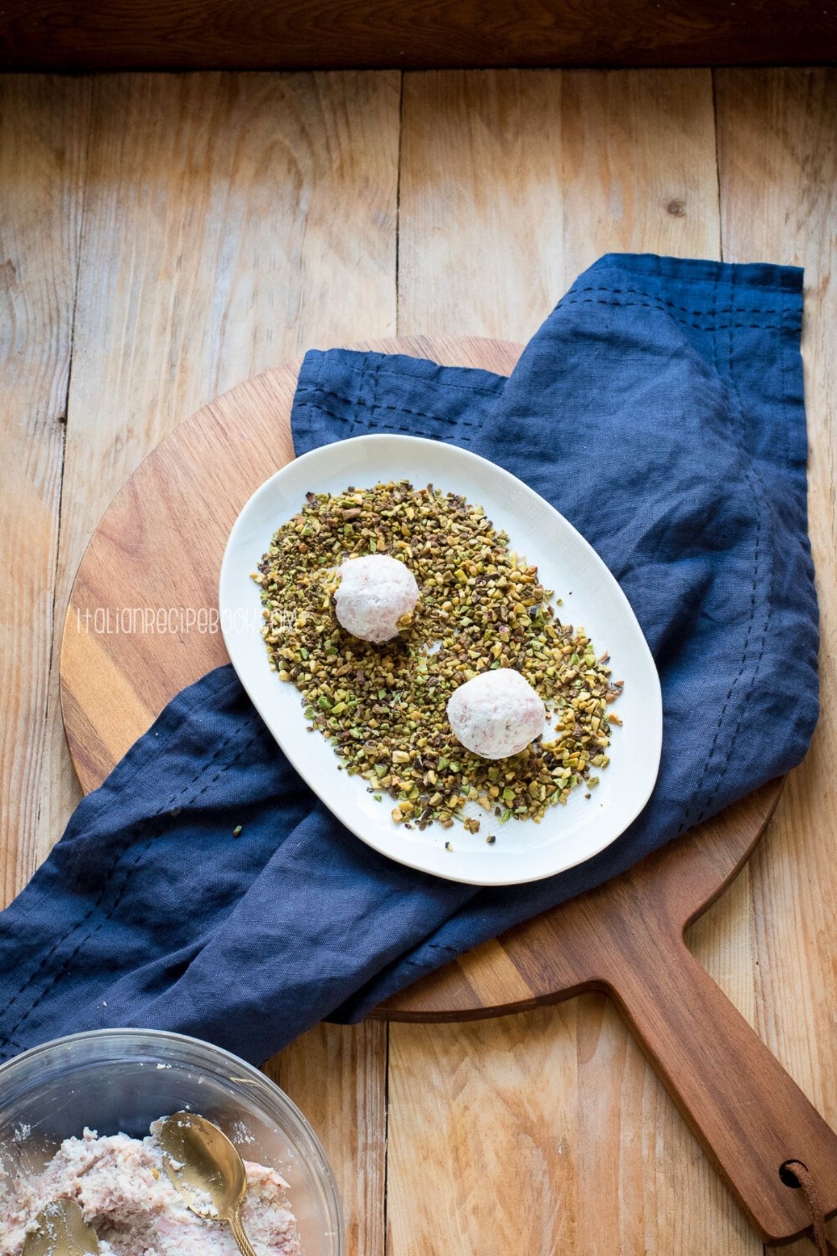 rolling ricotta ball in chopped pistachios