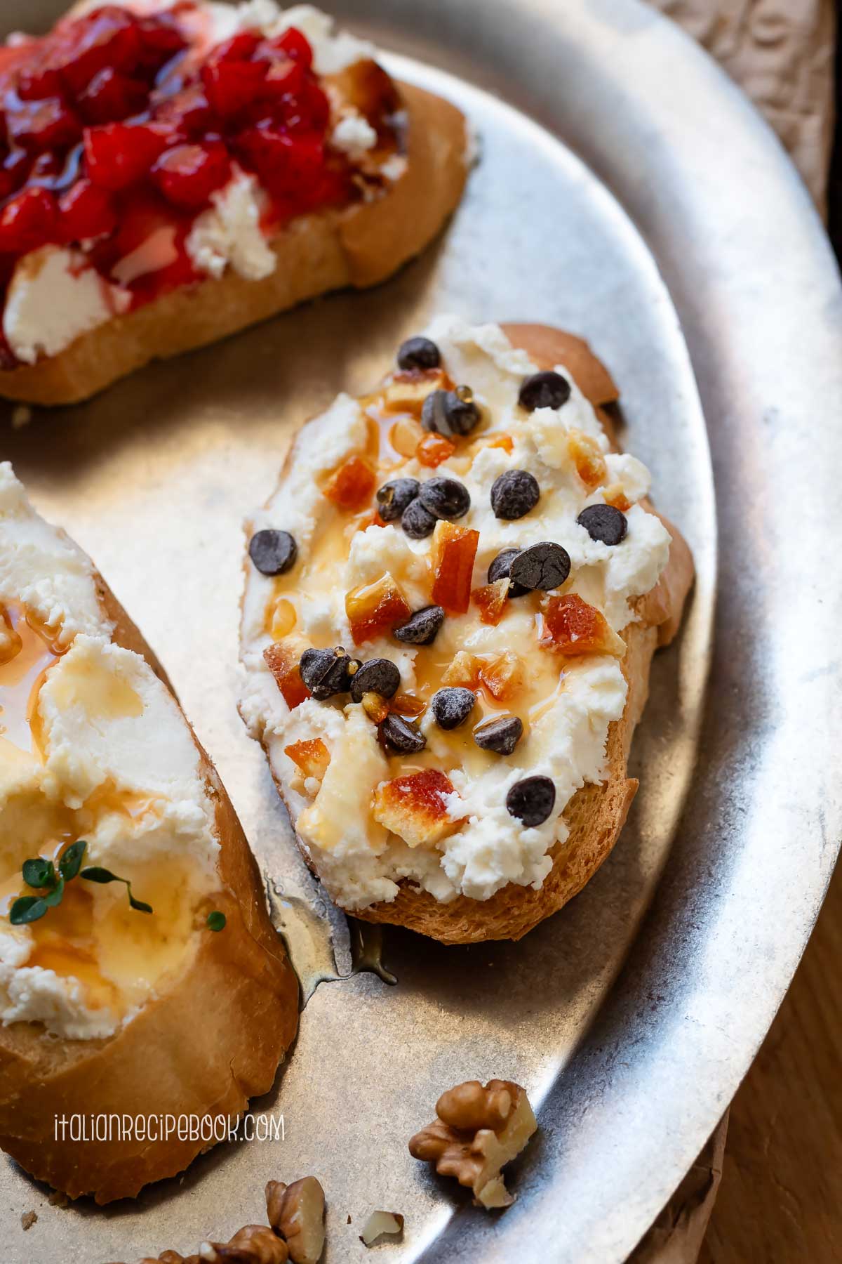 Ricotta crostino topped with candied oranges and chocolate chips.