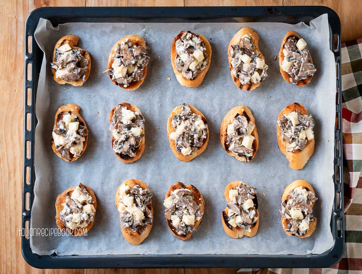 Mushroom crostini on a baking sheet before baking.
