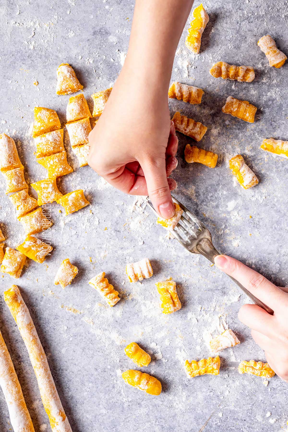 rolling pumpkin gnocchi over a fork