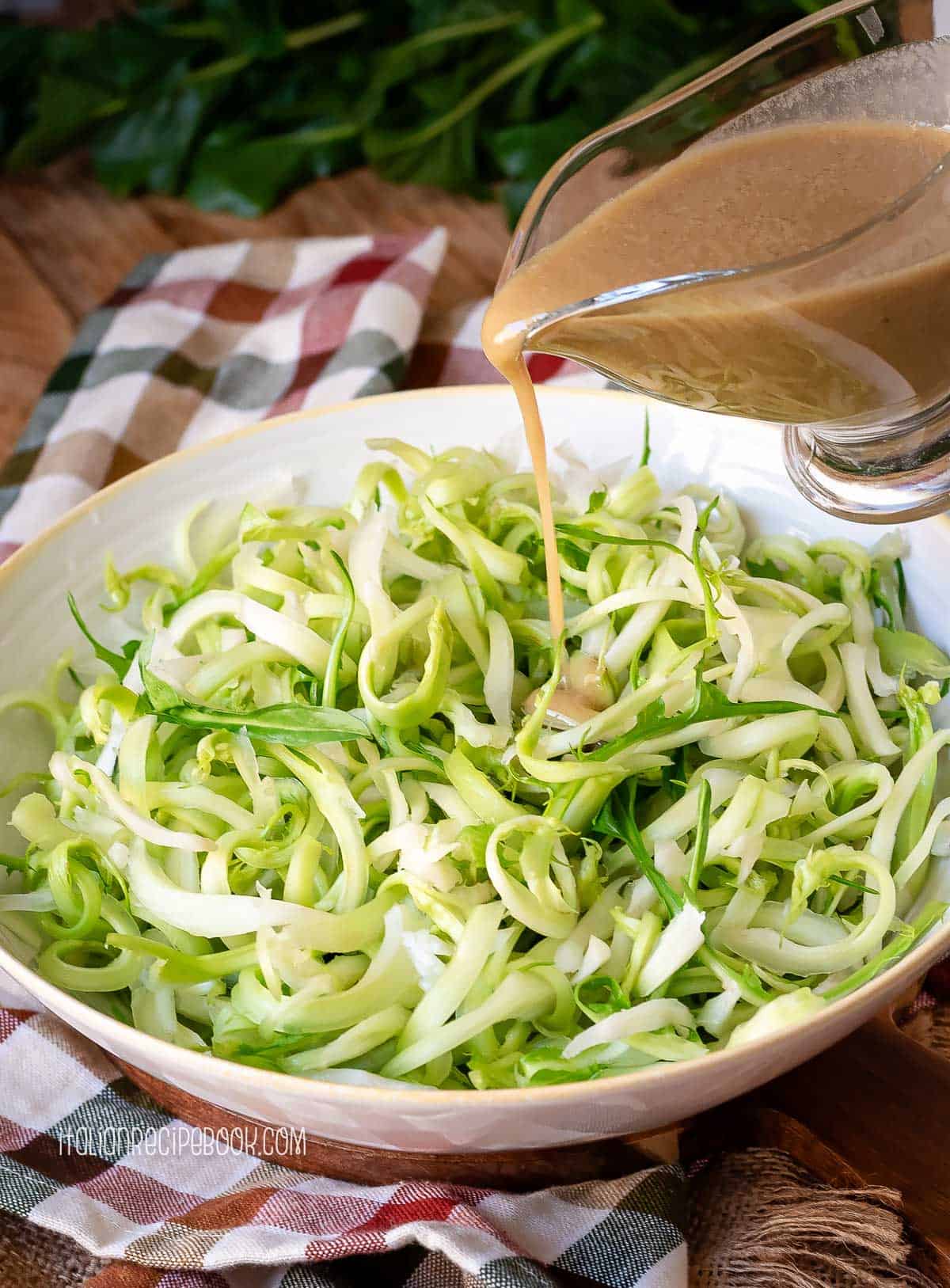 Pouring anchovy dressing over puntarelle.