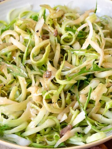 Puntarelle in a bowl with dressing.