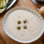 Salsa tonnata in a rimmed bowl, garnished with capers.