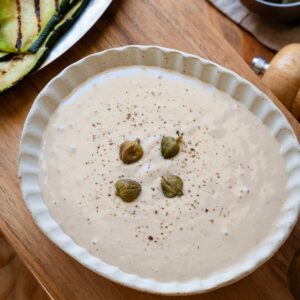 Salsa tonnata in a rimmed bowl, garnished with capers.