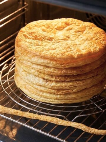 Puff Pastry layers stacked on a baking rack in the oven.