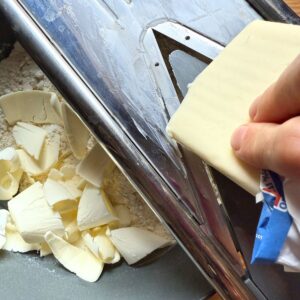 Slicing frozen butter on a mandoline into thin shavings.