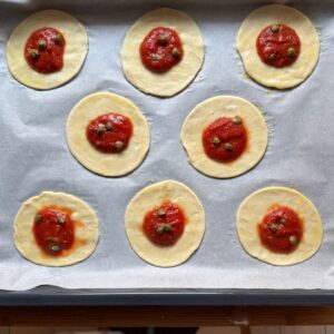 Puff pastry discs topped with the tomato sauce.
