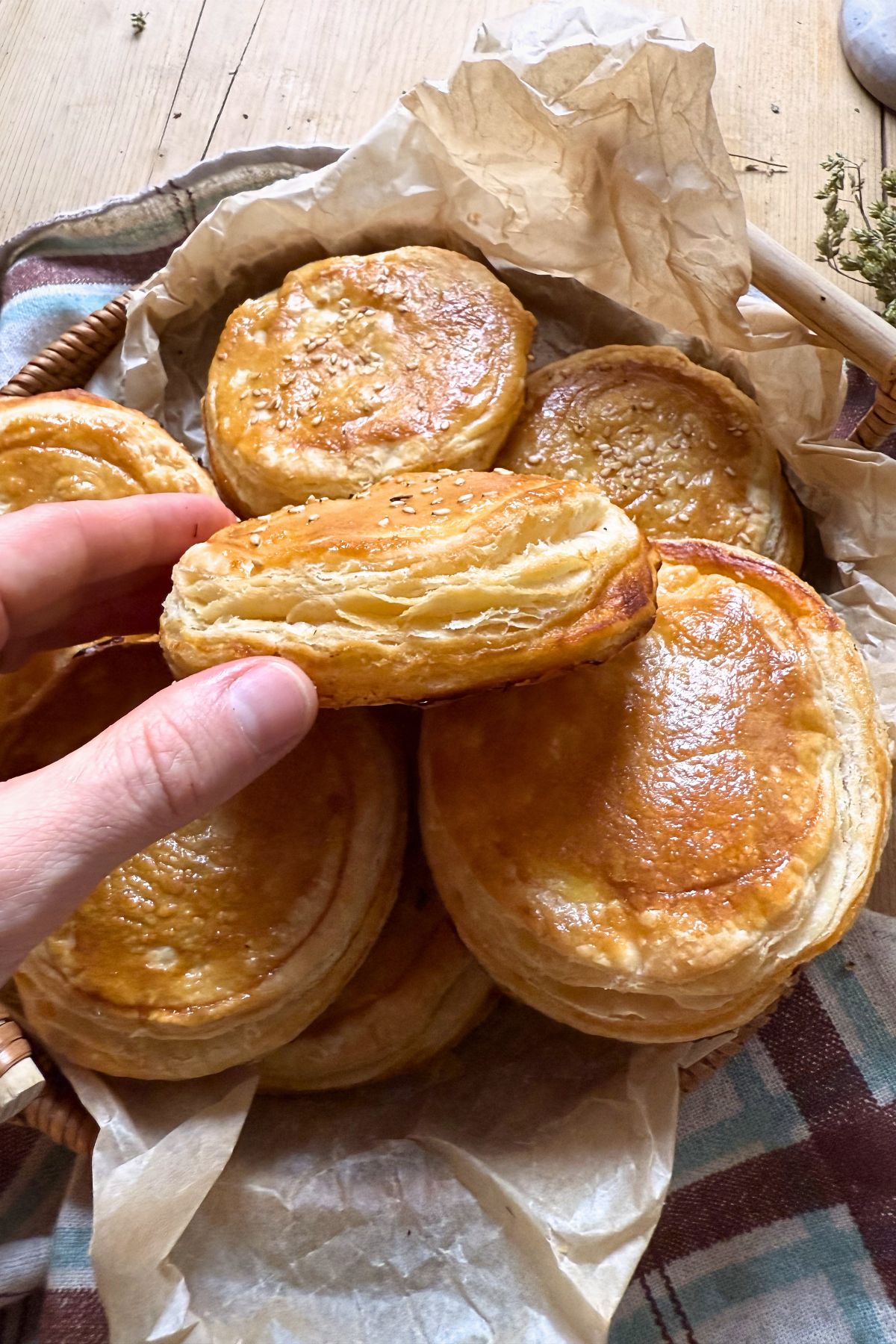 A hand holding a puff pasty pizzetta.