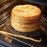 Puff Pastry layers stacked on a baking rack in the oven.