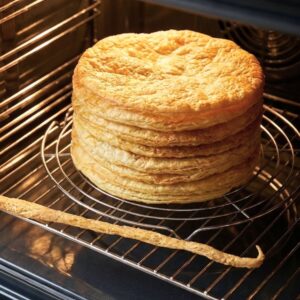 Puff Pastry layers stacked on a baking rack in the oven.