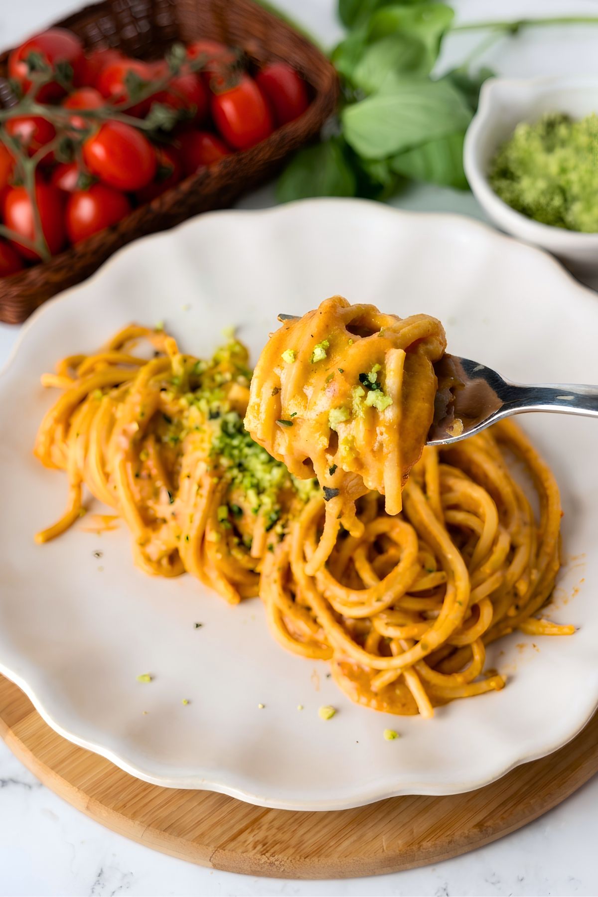 Spaghetti with roasted cherry tomato sauce twirled on a fork and topped with green Parmesan cheese.